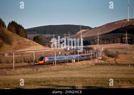 Virgin Trains Alstom Pendolino Kippzug 390005 in der schottischen Landschaft auf der elektrifizierten Hauptlinie der Westküste, kippend um eine Ecke Stockfoto