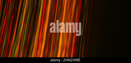 Mehrfarbige Strahlen auf dunklem Hintergrund. Abstraktion. Zeichnen mit Licht. Fotoeffekt. Stockfoto