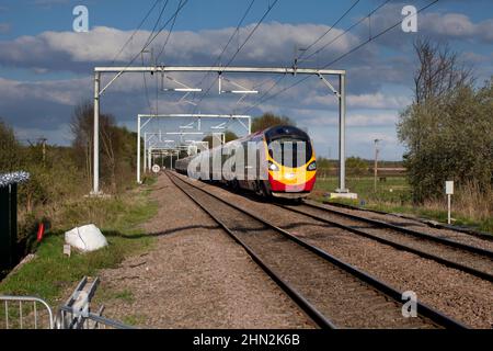 Virgin Züge Alstom Pendolino Zug vorbei Astley auf der Chat MOSS Bahnlinie, Lancashire, Großbritannien, mit einem umgelendenen Zug Stockfoto