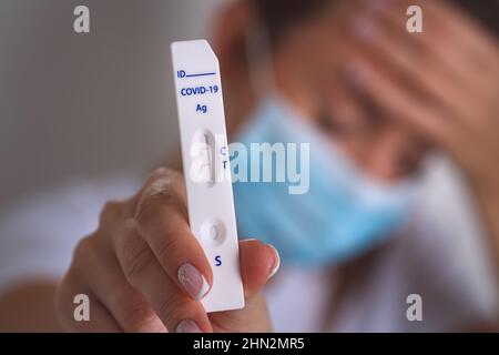 Kranke infizierte Frau mit schnellem Covid-Antigen-Test oder Express-Covid-Test mit positivem Covid-19-Ergebnis. Frau mit Coronavirus-Infektion Stockfoto