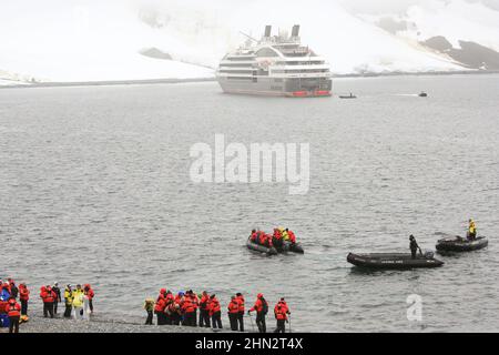 Passagiere des Le Boreal-Kreuzfahrtschiffs, die nach dem Besuch der Pinguinkolonien mit Zodiac-Booten auf der Insel Half Moon in der Antarktis zum Schiff zurückkehren. Stockfoto