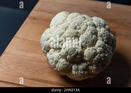 Blumenkohl ganz auf einem Holzbrett Stockfoto