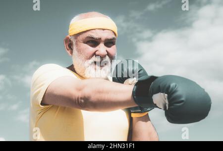 Bestes Cardio-Workout. Älterer Mann, der auf einen Boxsack trifft. Gesunde Kämpfer Senior alten Mann Boxhandschuhe. Boxer mit Boxhandschuh. Ich liebe Boxen. Schön Stockfoto