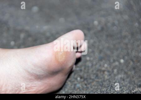 Der Fuß der Frau schwallt über den Sand. Fußpflege und Gesundheit Stockfoto