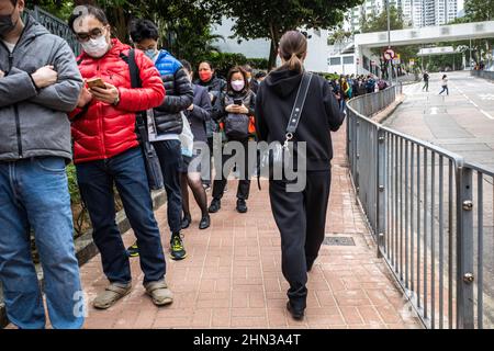 Hongkong, China. 09th. Februar 2022. Einwohner Hongkongs stellen sich für ihren COVID-19-Test an. Mit der Omicron-Variante, die Hongkongs „Zero COVID“-Eindämmungsstrategie durchbricht, haben Zehntausende Hongkonger in den letzten Tagen Schlange stehen, um getestet zu werden, viele davon unter den vom Zentrum für Gesundheitsschutz herausgegebenen obligatorischen Testhinweisen. (Foto von Ben Marans/SOPA Images/Sipa USA) Quelle: SIPA USA/Alamy Live News Stockfoto