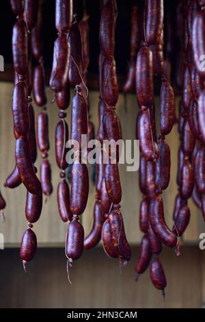 Frisch zubereitete Würstchen mit Schweinefleisch und Trocknung mit Holzrauch und Luft aufgehängt. Stockfoto