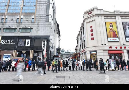 Peking, China. 12th. Februar 2022. In Peking, der Hauptstadt Chinas, stehen Menschen in der Wangfujing-Straße Schlange, um Bing Dwen Dwen Spielzeug zu kaufen, 12. Februar 2022. Quelle: Chen Zhonghao/Xinhua/Alamy Live News Stockfoto