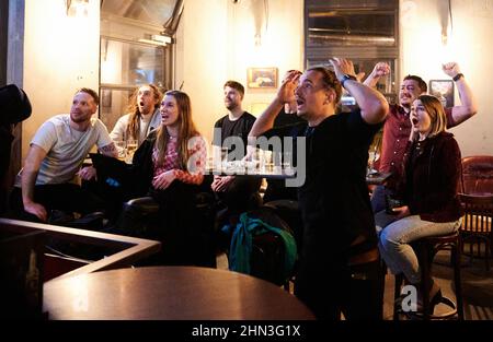 Berlin, Deutschland. 14th. Februar 2022. Fans vor einem Fernseher jubeln in einem Pub die beiden amerikanischen Fußballmannschaften an. Die Los Angeles Rams gewannen den Super Bowl 56th und verhinderten, dass die Cincinnati Bengals ihren ersten NFL-Titel am Sonntag, den 13. Februar 2022, in Los Angeles gewannen. Quelle: Annette Riedl/dpa/Alamy Live News Stockfoto