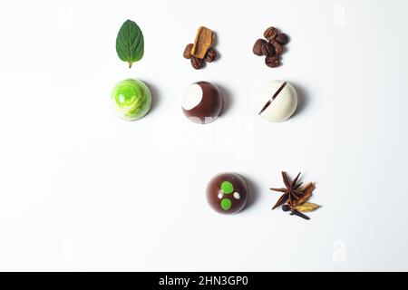 mexikanische bunte Schokolade Bonbons mit Minzblättern, Zimt und Kaffeebohnen auf weißem Hintergrund Stockfoto