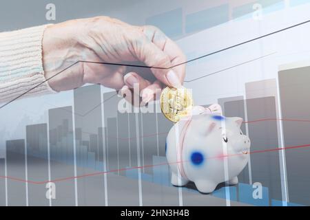 Faltige Weibchen legen eine Bitcoin ein Sparschwein. Business Chart im Hintergrund. Doppelbelichtung. Das Konzept der Investition und Versicherung. Stockfoto