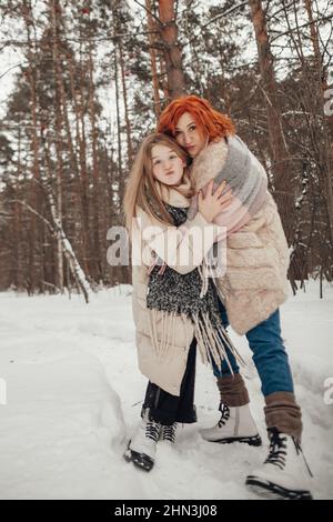 Zwei Mädchen, die Spaß im Winterwald haben Stockfoto