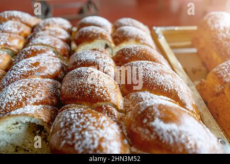 Frische Mehlbrötchen, die mit Puderzucker bestreut wurden, oben direkt aus dem Ofen. Stockfoto