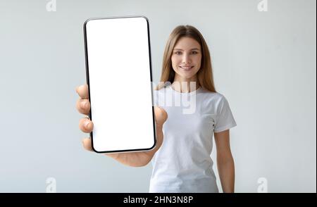 Dame hält Mobiltelefon mit leerem Bildschirm in der Hand Stockfoto