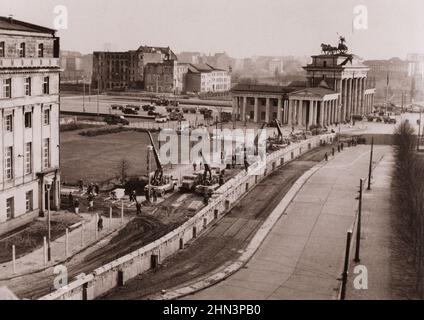 Vintage-Foto der Berliner Krise von 1961: Mauerbau Berliner Mauer verstärkt. Unter den wachsamen Augen der kommunistischen Polizei waren ostdeutsche Arbeiter in der Nähe Stockfoto