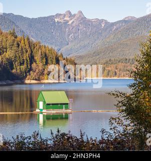 Wunderschöne Herbstlandschaft eines Bootshauses auf einem See und Bergen am Cleveland Dam Stausee in der Nähe von North Vancouver BC Stockfoto