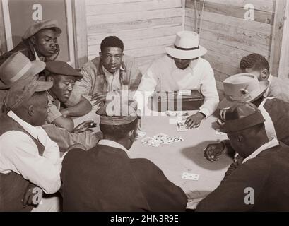 Vintage-Foto des amerikanischen Südens im Jahr 1940s. Wanderarbeiter und Gemüsepflücker spielen im Belle Glad ein „Schlangenspiel“ hinter dem Juke-Joint und der Bar Stockfoto