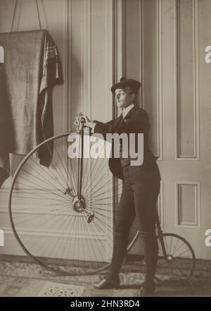 Vintage-Foto von Frances Benjamin Johnston (Fotografin), Selbstporträt gekleidet als Mann mit falschem Schnurrbart, posiert mit Fahrrad. Zwischen 1890-1900 Stockfoto