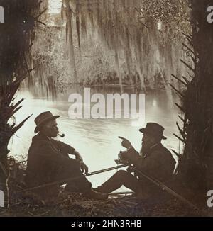 Vintage-Foto von zwei älteren Männern, die unter silbrig-spanisches Moos, Blue Spring, Florida, sprechen. USA. 1900s Stockfoto