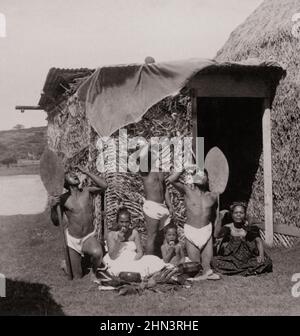 Vintage-Foto einer Gruppe von Kanaka Maoli, die Poi auf den Hawaiianischen Inseln essen (vor der Grashütte). 1896 Ureinwohner Hawaiis sind die indigenen Polynesien Stockfoto