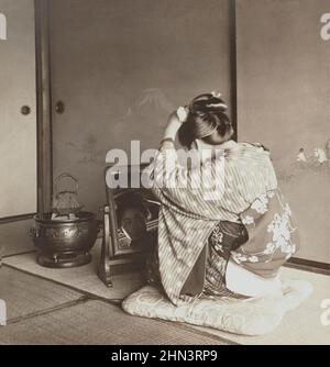 Vintage-Foto einer japanischen Frau im traditionellen Kimono, die im Spiegel aussieht. 1905 Stockfoto