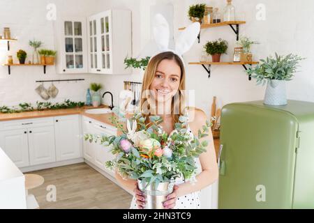 Schöne Frau trägt Hasenohren Posen in der Küche. Frohe Ostern Hintergrund. Stockfoto