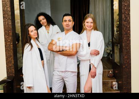 Schöner lächelnder Kunde, der sich mit einem männlichen Massagemeister zufrieden fühlt Stockfoto