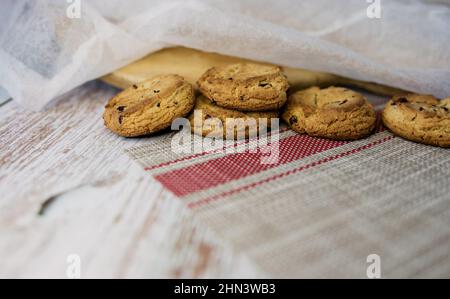 Leckere Plätzchen und Zimtstangen auf einem Holztisch. Ungesunde Nahrung Stockfoto