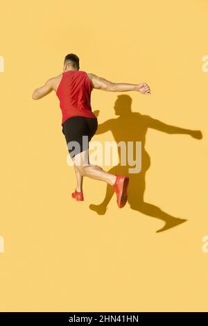 Mann in Rot mit Schatten auf gelbem Hintergrund Stockfoto