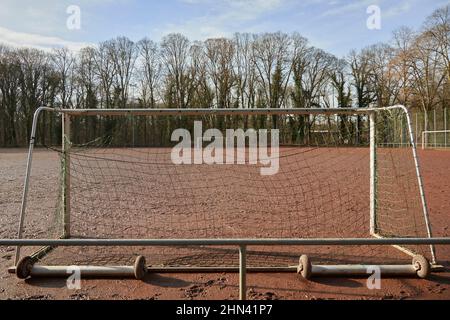 Blick durch ein Tor zu einem anderen auf einem roten Fußballfeld Stockfoto