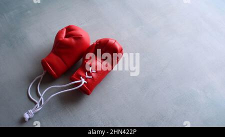 Sporttrainingskonzept. Rote Boxhandschuhe auf Betonboden mit Platz für Text Stockfoto