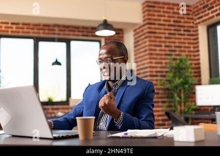 Mitarbeiter des Unternehmens halten sich fest, um geschäftliche Erfolge am Arbeitsplatz zu feiern. Glücklicher Unternehmer glücklich und zufrieden nach Marketing-Sieg und Leistung in Startup-Office. Stockfoto