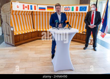 14. Februar 2022, Mecklenburg-Vorpommern, Schwerin: Bundesminister für Wirtschaft und Klimaschutz, Robert Habeck (Bündnis 90/die Grünen), beantwortet neben Reinhard Meyer (SPD, r), Minister für Wirtschaft, Tourismus und Verkehr Mecklenburg-Vorpommerns, Während einer Pressekonferenz im Wirtschaftsministerium Mecklenburg-Vorpommerns vor einem Strandstuhl mit den Flaggen verschiedener Länder. Habeck besucht nach einem Treffen mit dem Landesabteilungsleiter Meyer die insolventen MV Shipyards Group und das Wasserstoffenergieunternehmen Apex in Rostock-Laage. Stockfoto