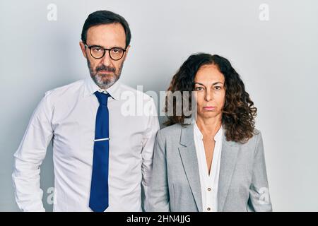 Mittelalterpaar hispanische Frau und Mann tragen Geschäftsbüro Uniform depressiv und sorgen sich um Not, Weinen wütend und Angst. Trauriger Ausdruck. Stockfoto