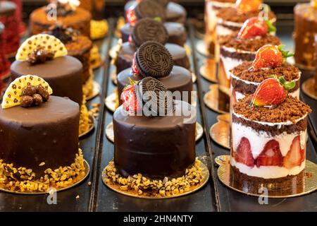 Kleine Kuchen auf dem Display an der Patisserie-Theke Stockfoto