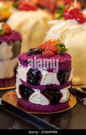 Fruchtiger Kuchen. Kleine Kuchen auf dem Display an der Patisserie-Theke Stockfoto