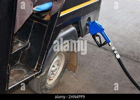 Nahauflaufdüse – Kraftstoffpumpe, die eine automatische Rikscha an einer Tankstelle einfüllt. Bhopal City, Madhya Pradesh, Indien. Stockfoto