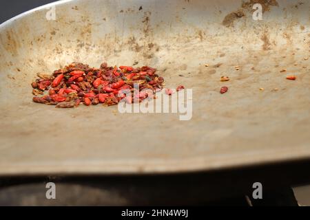 Getrocknete Chilischote mit roten Vogelaugen auf einem Stahlwinnow Stockfoto