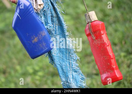 Leere und abfallende Plastikflaschen, die am Seil hängen Stockfoto