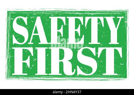 SICHERHEIT ZUERST, Worte auf grünem grungy Stempelschild geschrieben Stockfoto