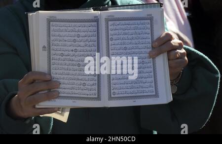 Eine Palästinenserin hält den Koran, das Buch des Islam hoch als rechtsextreme Knesset-Mitglied Itamar Ben-Gvir kommt, um sein "parlamentarisches Büro" zwischen dem Haus eines Palästinensers, der einer Räumung gegenübersteht, und dem Haus eines jüdischen Siedlers zu eröffnen, das angeblich am 13. Februar im Viertel Sheikh Jarrah in Brand gesetzt wurde. 2022, in Jerusalem, Israel. Das palästinensische Viertel Sheikh Jarrah ist derzeit das Zentrum einer Reihe von Eigentumsstreitigkeiten zwischen Palästinensern und rechtsgerichteten jüdischen Israelis. Einige Häuser wurden nach einem Gerichtsurteil von israelischen Siedlern besetzt. Stockfoto