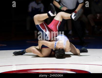 Wrestler hat Gegner während eines Wrestling-Matches in der High School auf den Kopf gestellt. Stockfoto