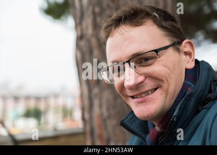 Außenportrait eines 40-jährigen Mannes, lächelnd Stockfoto