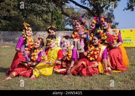 Dhaka, Dhaka, Bangladesch. 14th. Februar 2022. Frauen und Kinder, die traditionelle Kleider mit Blumenschmuck tragen, treten während des ''Basanta Utsab'' (Frühlingsfest) auf, auch ''Pohela Falgun'' genannt, dem ersten Frühlingstag des bengalischen Monats ''Falgun'', in Dhaka, Bangladesch. Das knallende Rot und Gelb sind die repräsentativen Farben von ''Pohela Falgun''. Kredit: ZUMA Press, Inc./Alamy Live Nachrichten Stockfoto