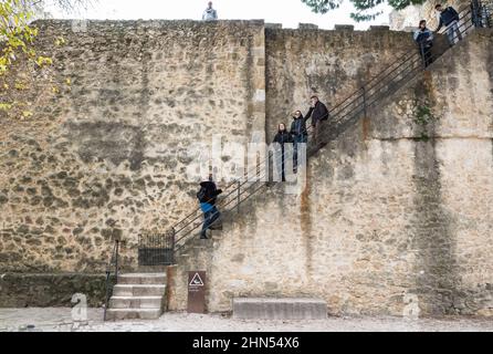 Lissabon, Portugal - 12 26 2018: Touristen, die bei einem Besuch die alten Treppen des Schlosses Saint George hoch und runter gehen. Stockfoto