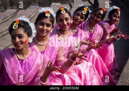 Dhaka, Dhaka, Bangladesch. 14th. Februar 2022. Frauen und Kinder, die traditionelle Kleider mit Blumenschmuck tragen, treten während des ''Basanta Utsab'' (Frühlingsfest) auf, auch ''Pohela Falgun'' genannt, dem ersten Frühlingstag des bengalischen Monats ''Falgun'', in Dhaka, Bangladesch. Das knallende Rot und Gelb sind die repräsentativen Farben von ''Pohela Falgun''. Kredit: ZUMA Press, Inc./Alamy Live Nachrichten Stockfoto