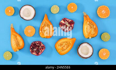 Kreative Szene von geschnittenen Bio-Früchten auf hellem cyanfarbenem Hintergrund. Flach Lay-Muster Konzept Stockfoto