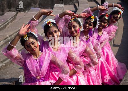 Dhaka, Dhaka, Bangladesch. 14th. Februar 2022. Frauen und Kinder, die traditionelle Kleider mit Blumenschmuck tragen, treten während des ''Basanta Utsab'' (Frühlingsfest) auf, auch ''Pohela Falgun'' genannt, dem ersten Frühlingstag des bengalischen Monats ''Falgun'', in Dhaka, Bangladesch. Das knallende Rot und Gelb sind die repräsentativen Farben von ''Pohela Falgun''. Kredit: ZUMA Press, Inc./Alamy Live Nachrichten Stockfoto