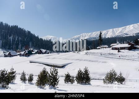 Baramulla, Indien. 12th. Februar 2022. Ein Blick auf schneebedeckte Umgebung und schneebedeckte Berge an einem sonnigen Tag in Gulmarg. Gulmarg ist eine Stadt, eine Bergstation, ein beliebtes Skiziel und ein mitteiltes Gebietskomitee im Baramulla-Distrikt Jammu und Kaschmir. Die Stadt liegt in der Pir Panjal Range im westlichen Himalaya und liegt innerhalb der Grenzen des Gulmarg Wildlife Sanctuary. Kredit: SOPA Images Limited/Alamy Live Nachrichten Stockfoto