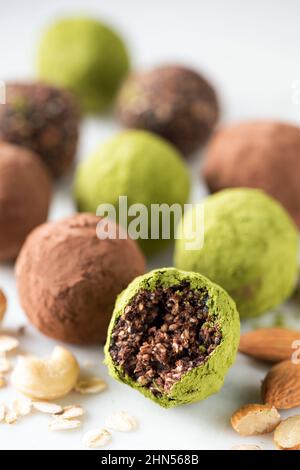 Vegane Schokoladentrüffel mit Nüssen und grünem Tee Matcha. Nahaufnahme. Trüffel fehlt Biss Stockfoto