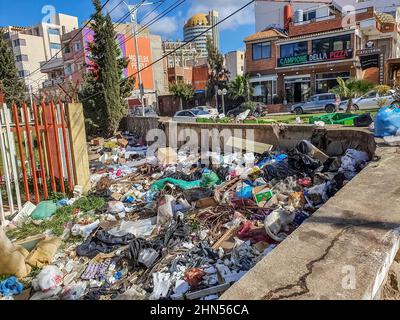 Ein vereinzelten Mülleimer. In der Nähe eines Pizza-Restaurants befindet sich die Campione della Pizza und der Housecourt von Cheraga. Wir können die Kuppel des ElQods Centers sehen. Stockfoto